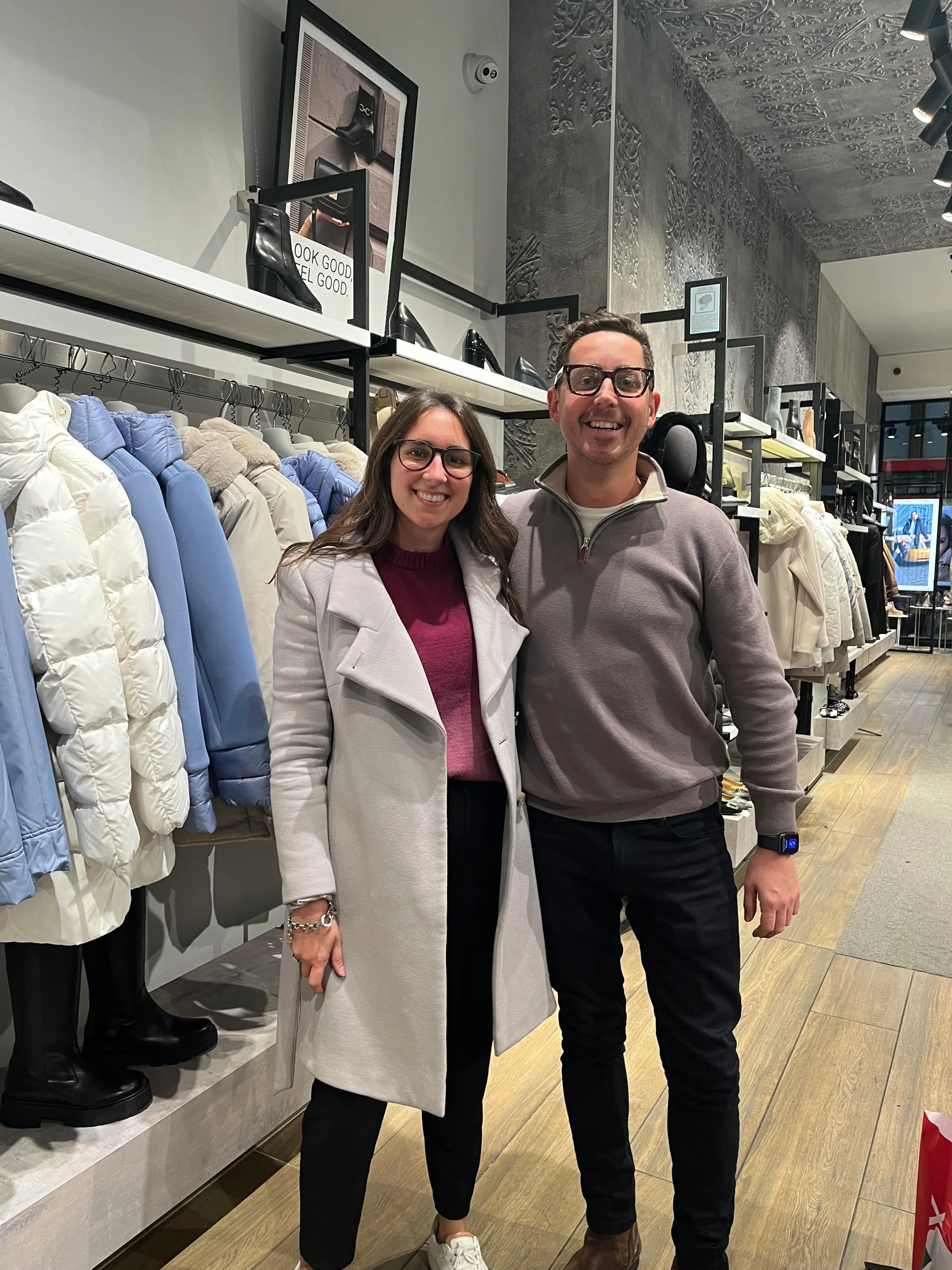 Maria Pastor with a smiling client in a grey jumper in a clothes shop