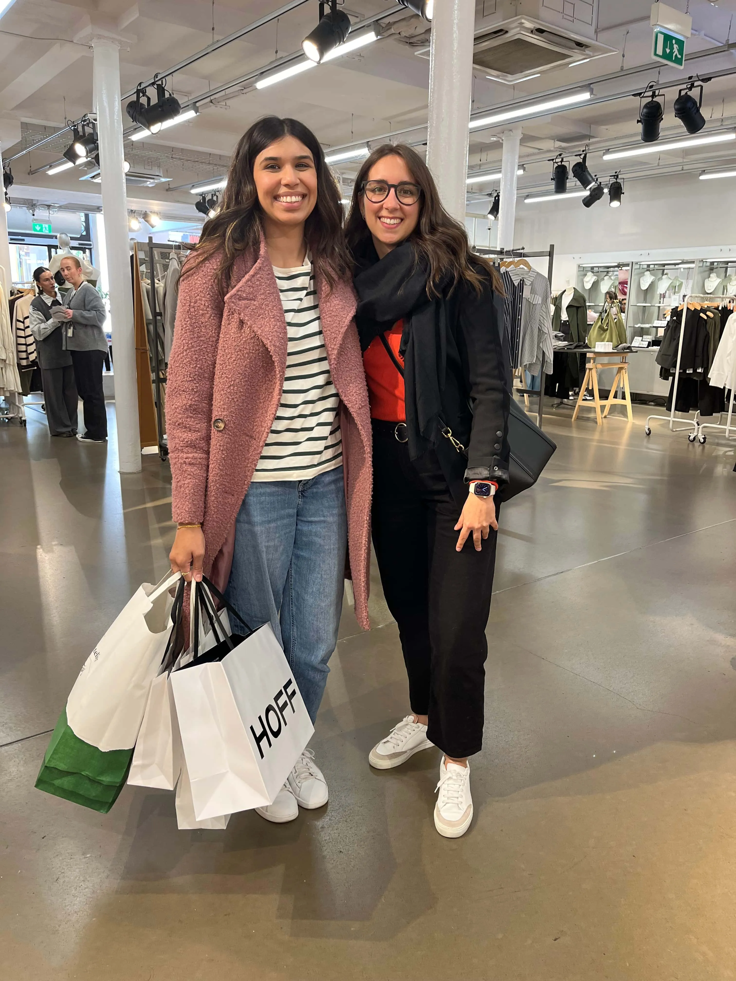 Maria Pastor with a smiling client in a pink coat holding her shopping bags