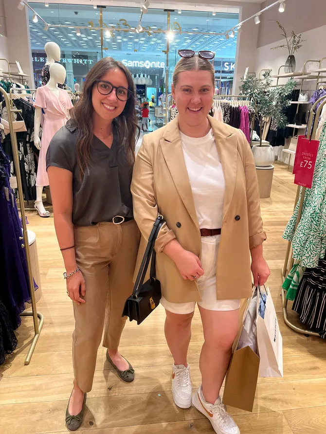 Maria Pastor with a smiling client in a camel blazer in a clothes shop