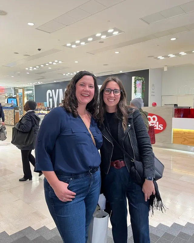 Maria Pastor with a smiling client in a navy blouse in a shopping centre
