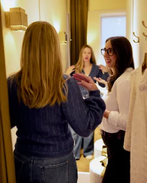 Maria Pastor talking with a client in front of a fitting-room mirror