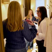 Maria Pastor talking with a client in front of a fitting-room mirror
