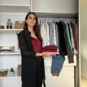 Maria Pastor holding curated clothing selections during a wardrobe edit session