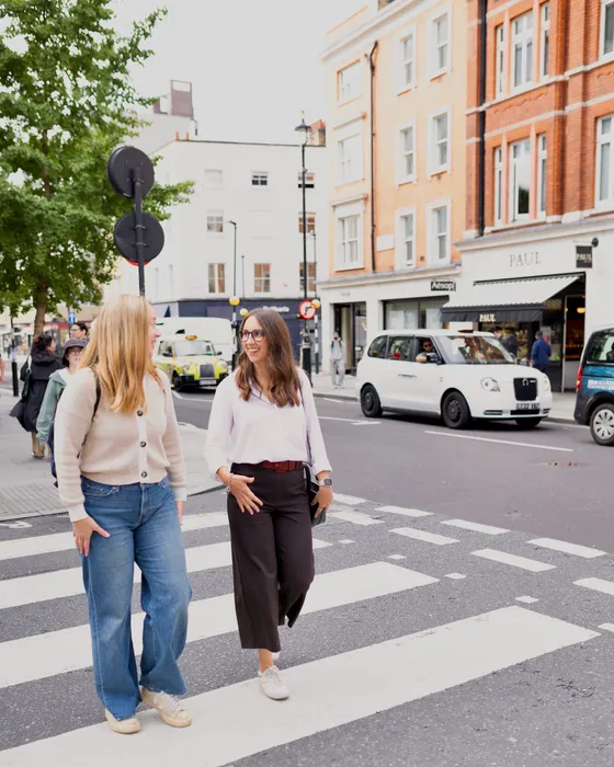 Maria Pastor walking with a client across a zebra crossing in central London, on the way to the next shop
