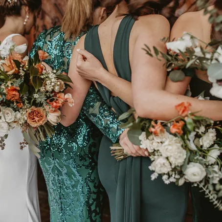 Bridesmaids in matching dresses holding bouquets